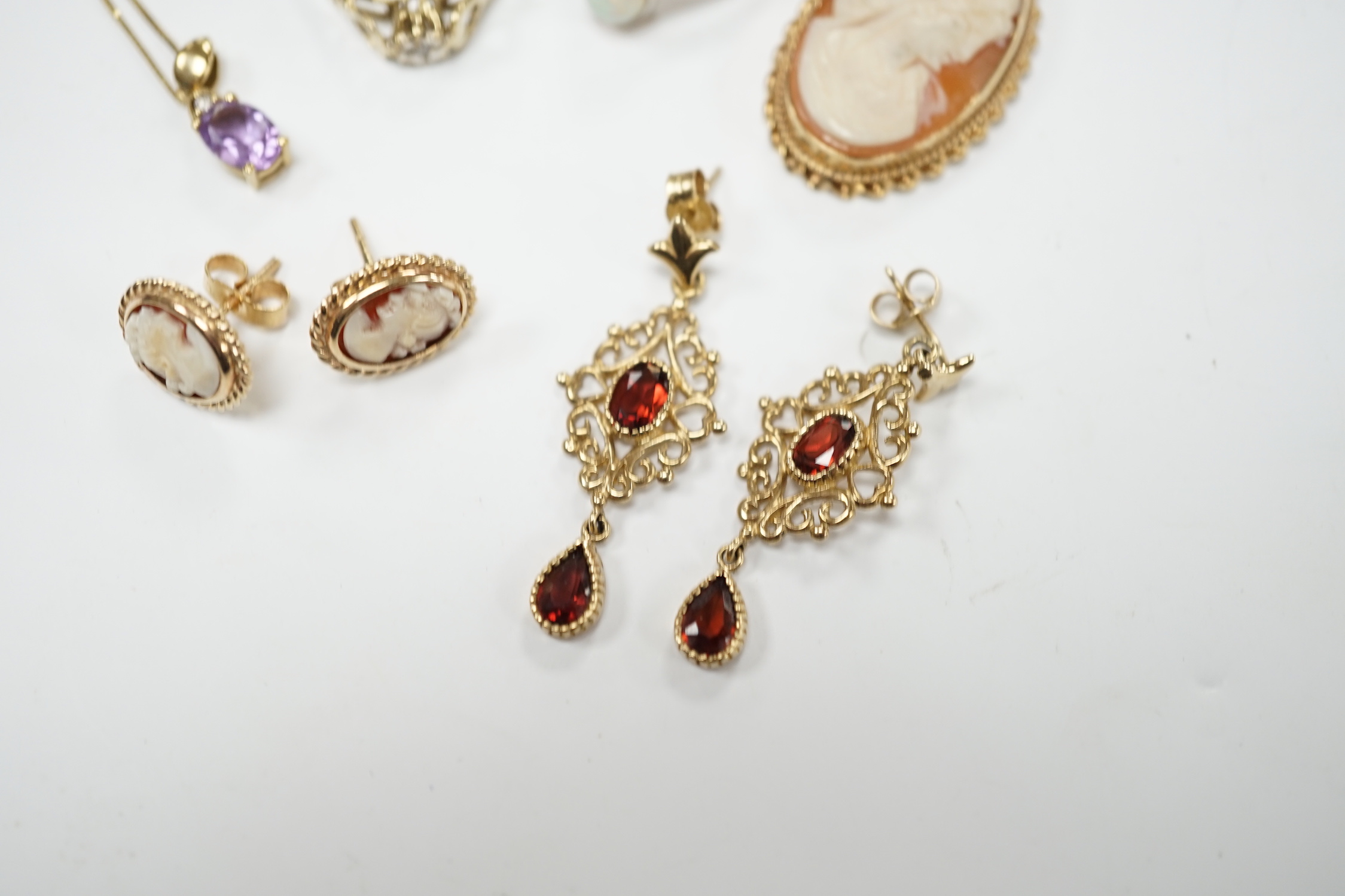 Two 9ct and gem set rings, including diamond chip and white opal, a 9ct and amethyst set pendant necklace, pair of 9ct gold and garnet earrings, a 9ct mounted cameo shell brooch and pair of matching earrings, gross weigh